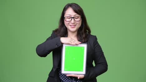 una hermosa mujer de negocios asiática madura mostrando una tableta digital