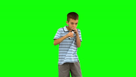 Little-boy-holding-a-microphone-and-singing-on-green-screen