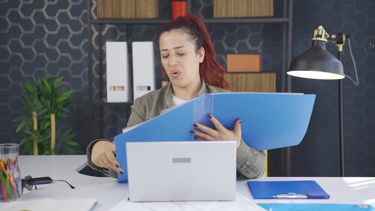 성공적인 사업가 여성이 서류 파일에서 행복하게 일하고 있습니다.