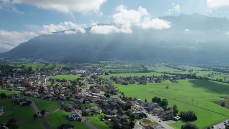 aerial view of liechtenstein with houses on green fields in alps mountain valley