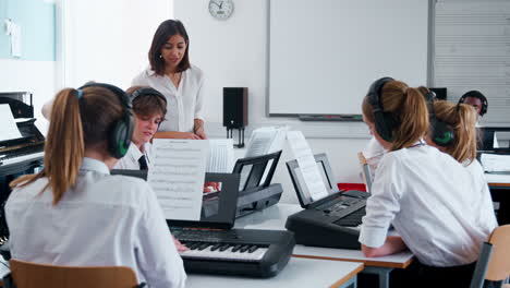 teenage students studying electronic keyboard in music class