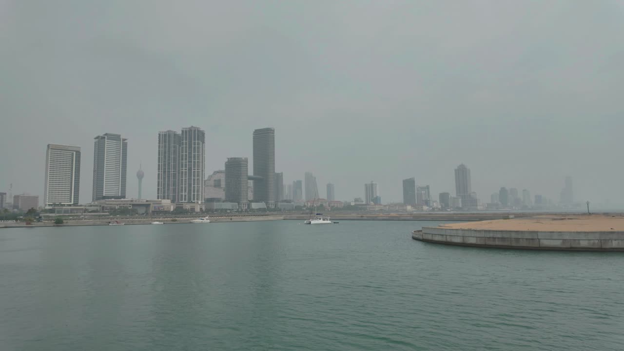 4K Video of a boat harbour with Colombo City skyline in the background on a very hazy day in Sri Lanka