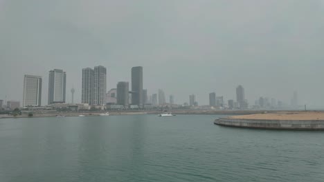 4k video of a boat harbour with colombo city skyline in the background on a very hazy day in sri lanka