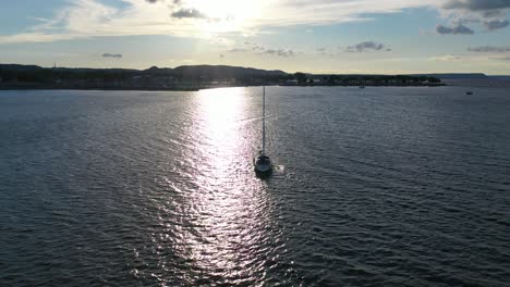 un velero al atardecer en el río