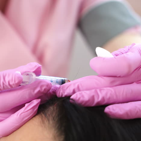 handsome woman receives an injection in the head. the concept of mesotherapy. thrust to strengthen the hair and their growth