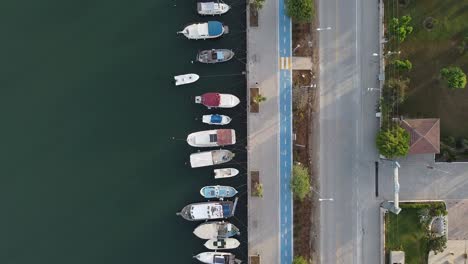 aerial top down view of parked boats on fethiye city coast next to street and cycleway, turkeyv