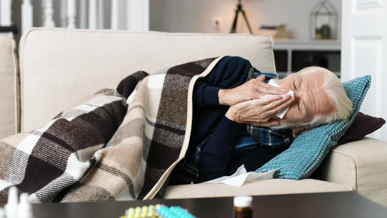 Very sick senior man lying on sofa in living room