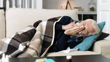 very sick senior man lying on sofa in living room