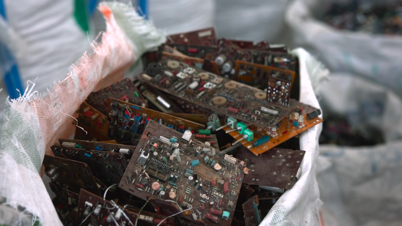 Bag Of Brown Circuit Boards, Stacked In Woven Sack At Smallscale Salvage Workshop Weathered Boards
