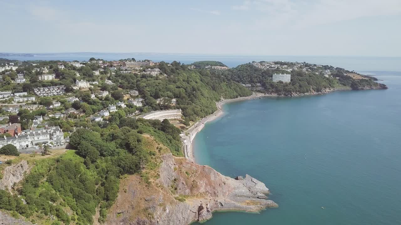 Aerial view of a coastal town with a beach and cliffs