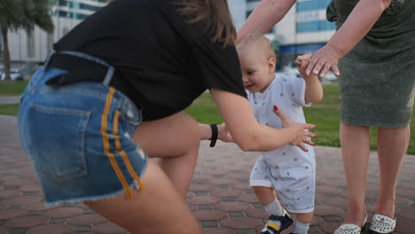 en el verano una joven madre caminando con un niño a lo largo del paseo marítimo.