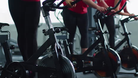 grupo de mujeres caucásicas sanas haciendo ejercicio en una bicicleta estacionaria en el gimnasio