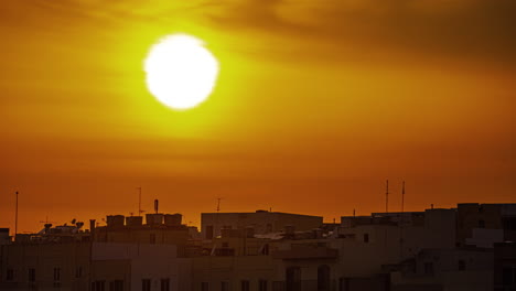 maltese township silhouette with bright sunset behind, time lapse view