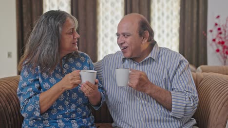 Old-Indian-couple-laughing-and-drinking-tea