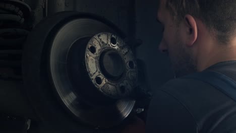 mecánico de automóviles trabajando en un disco de freno