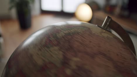 tight shot of a vintage globe spinning in a modern living room setting