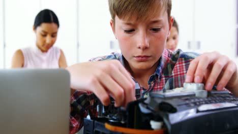 Schoolboy-repairing-a-printer-in-the-classroom