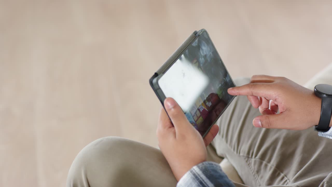 Vertical video: Man holding tablet index finger hovering tapping and swiping navigating apps for UX