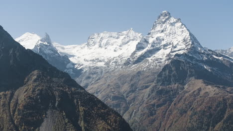 snowy mountain peaks in autumnal landscape
