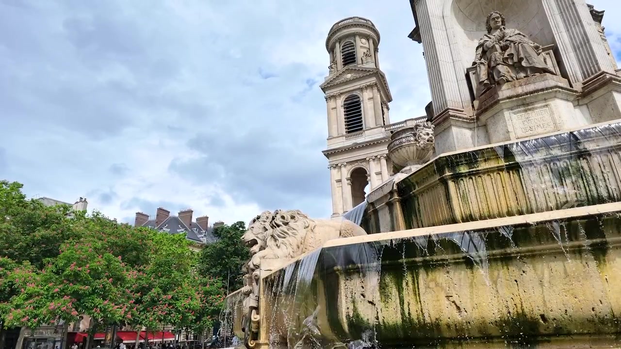 Toma en ángulo bajo de una fuente de piedra con agua en cascada y arquitectura clásica en París