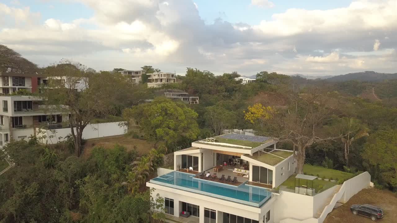 villas de lujo en una colina exuberante, drones volando alrededor y sobre villas y piscinas en costa rica