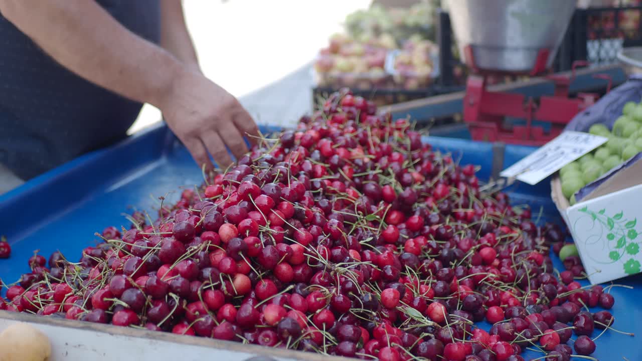 uomo che vende ciliegie al mercato