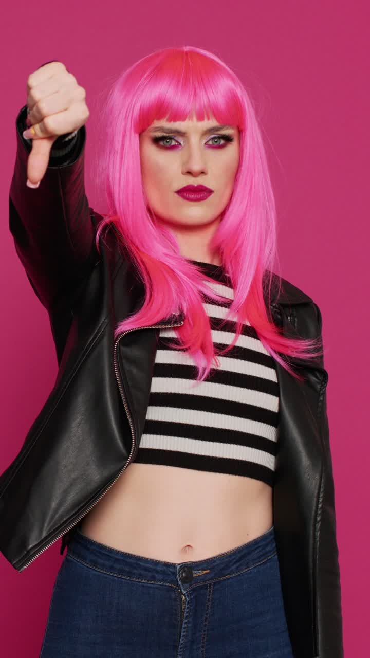 Video verticale: donna punk grintosa che mostra il pollice verso in studio