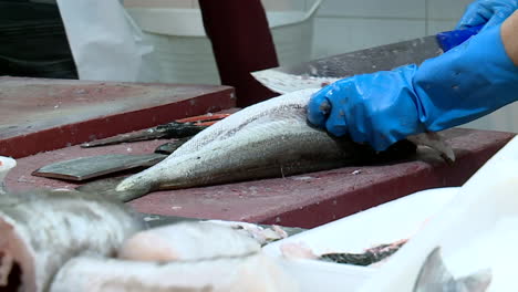 fishmonger at a market preparing fish