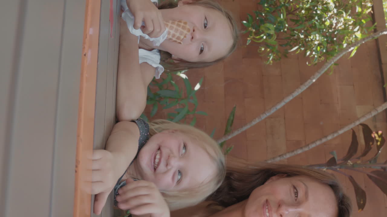 어린 어머니 가 어린 딸 들 과 함께 셀피 를 찍고 있다