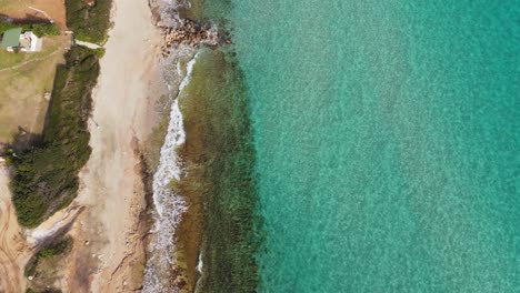 Beautiful-top-down-view-demonstrating-waves-hitting-the-beach-in-Afytos,-Chalkidiki,-Greece