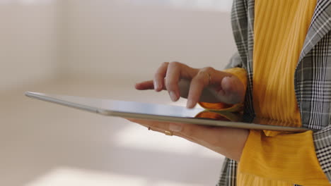 close up hands using digital tablet computer browsing online social media on mobile touchscreen device