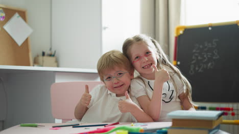 brother and sister bump fists and show thumbs-up smiling