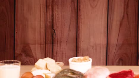 varias fuentes de proteínas mostradas en un fondo de madera