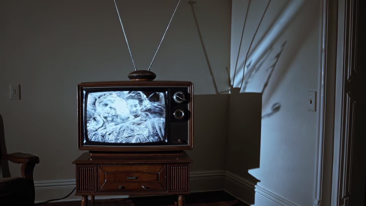 Ekranında statik olan eski bir TV, loş odada ürkütücü gölgeler oluşturuyor