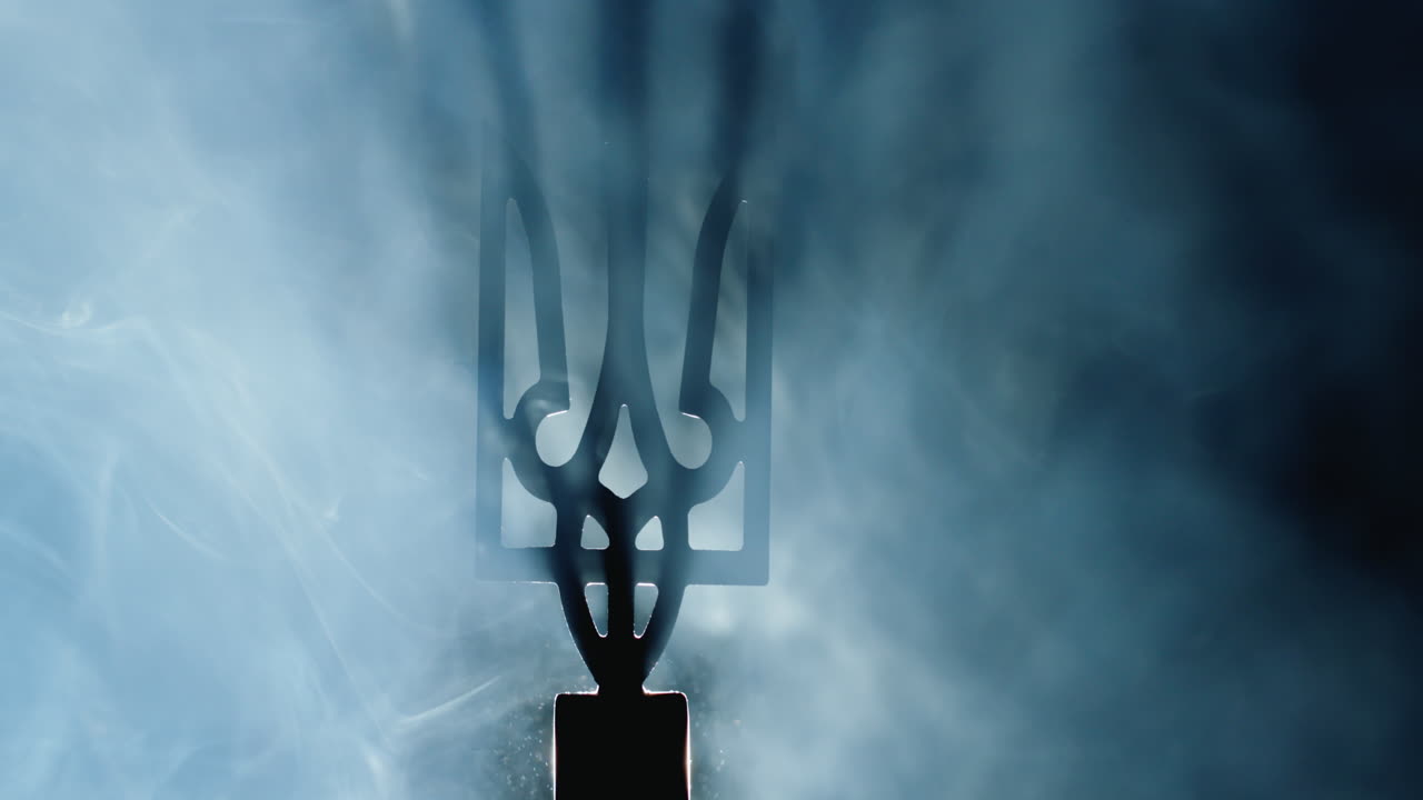 el escudo de armas de ucrania en la niebla, iluminado por un reflector