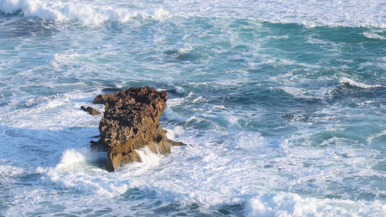 강력한 파도가 있는 바위가 있는 해안선