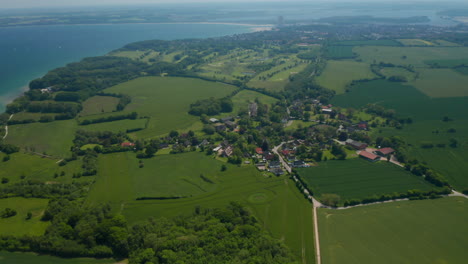 Schöne-Luftbildlandschaft-Von-Brodten,-Deutschland,-Fliegend-über-Gebäudehäusern-Mit-Ostsee-Im-Hintergrund,-Sonniger-Tag,-Kreispfanne