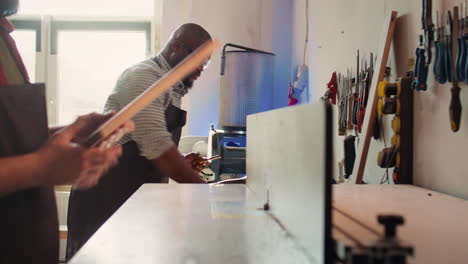 manufacturer and apprentice performing tasks on wood shaper