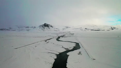 flying over the frozen river and road on winter in south iceland. - aerial drone