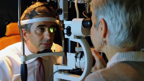 optometrista examinando los ojos del paciente con una lámpara de hendidura 4k