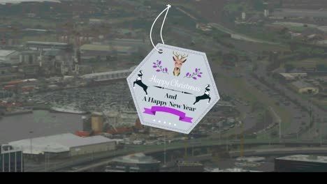 banner de texto de feliz navidad y año nuevo de forma hexagonal contra la vista aérea del paisaje urbano