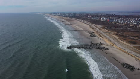 Ein-Drohnenblick-über-Einen-Leeren-Strand-Voller-Felsen-An-Einem-Diesigen-Tag