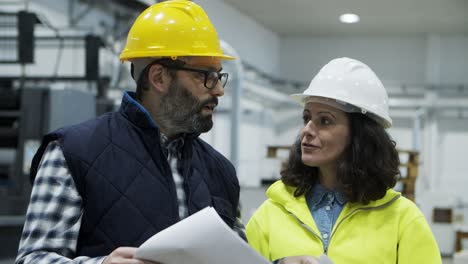 focused workers talking while inspecting quality of print