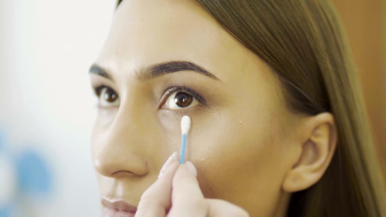 artista de maquillaje de bodas haciendo maquillaje para la novia. hermosa modelo sexy chica en el interior. mujer de belleza con cabello rizado. retrato femenino. mañana de novia de una dama linda. manos de primer plano cerca de la cara