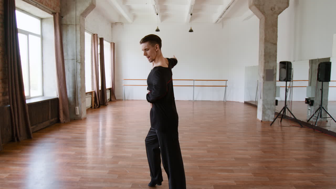 A male dancer performing in a bright studio