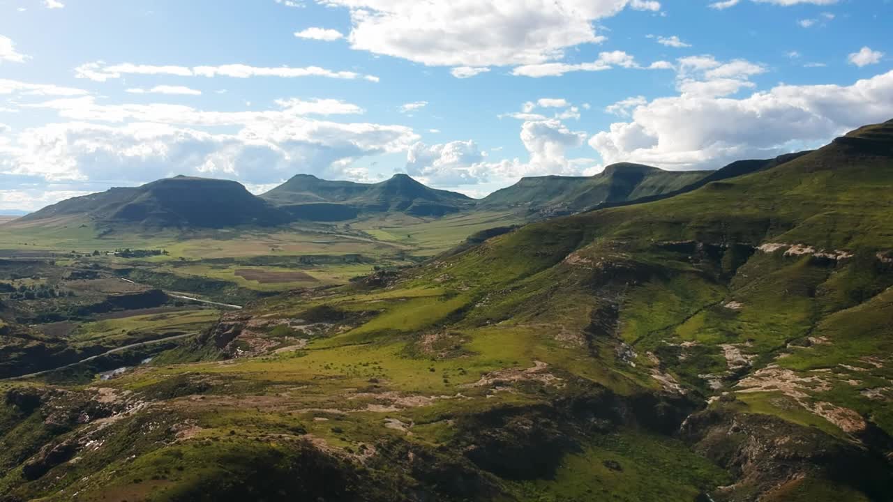Slow rising drone shot of green hills and valleys