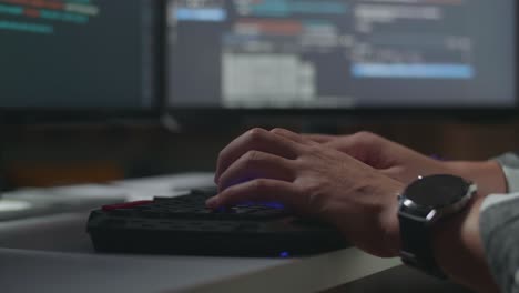 person typing on keyboard in front of computer screens