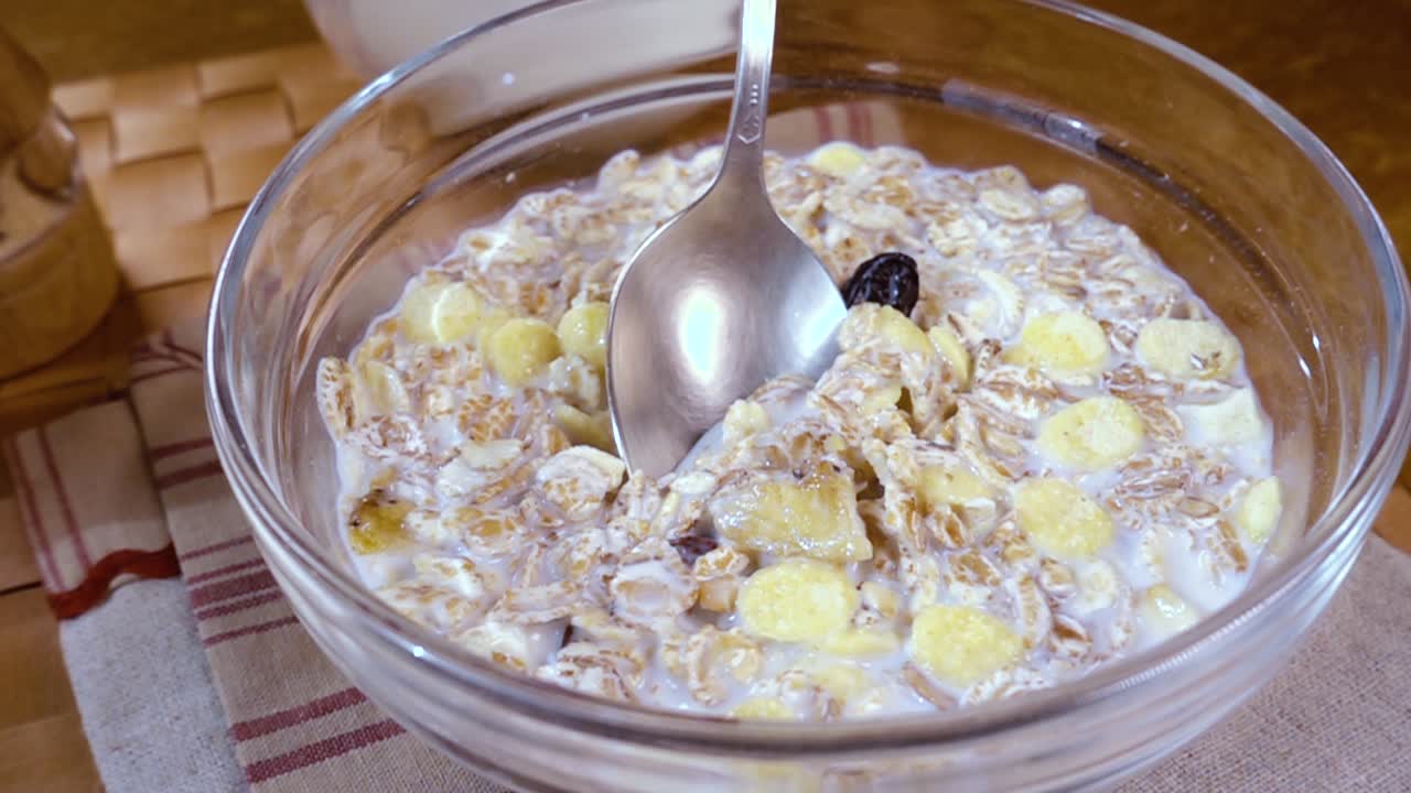 muesli de cereales de grano entero en un tazón para un delicioso desayuno matutino con leche. cámara lenta con toma de seguimiento de rotación.