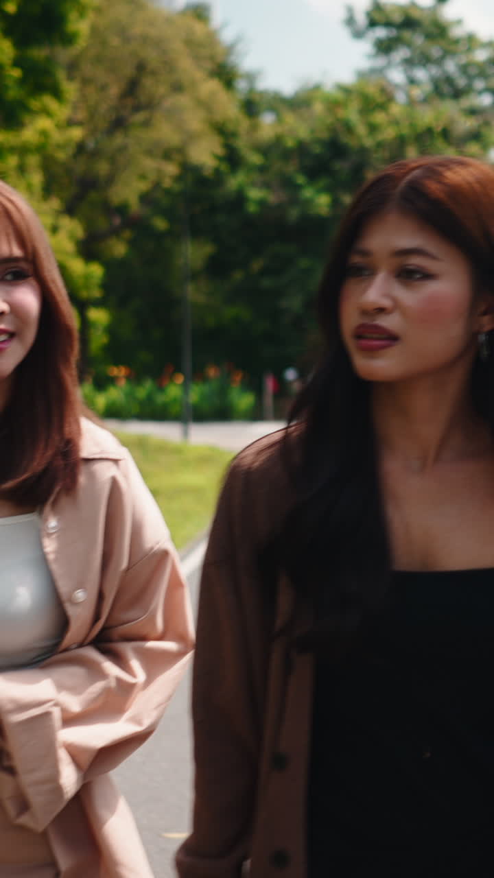 กลุ่มเพื่อนหญิงสาวชาวเอเชียมีความสุขกำลังเดินและพูดคุยในสวนสาธารณะ