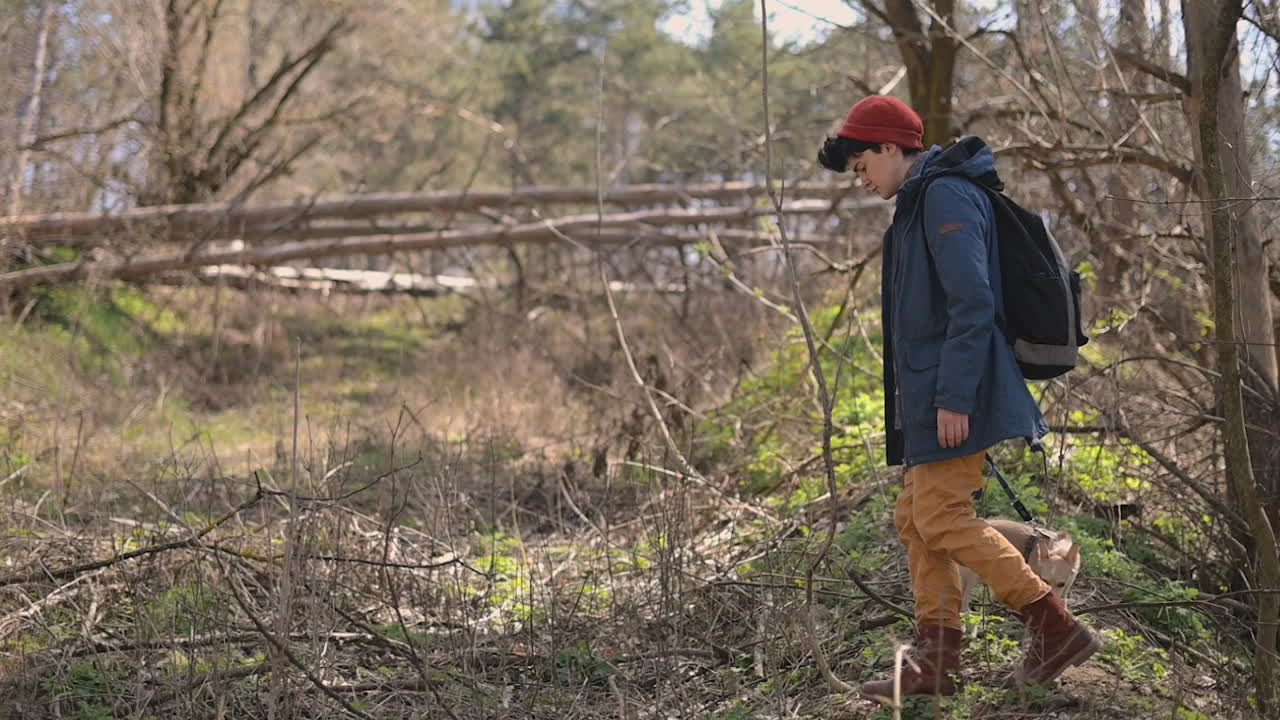 молодая женщина с короткими волосами гуляет по сельской местности со своей собакой